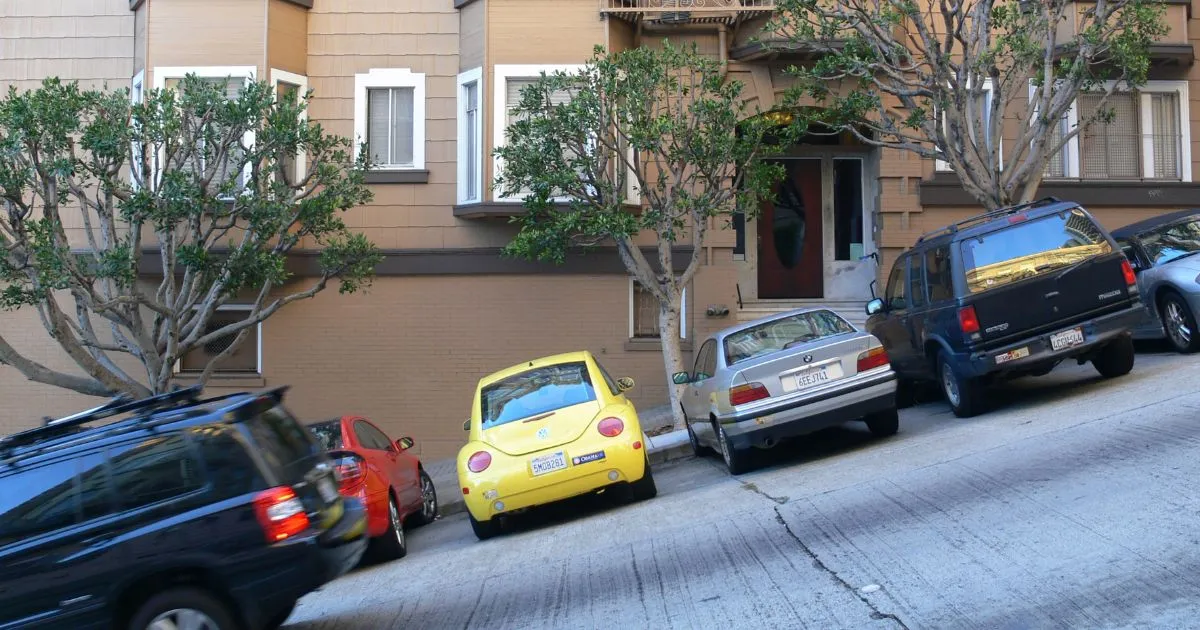 Urban street scene with cars parked on both sides, emphasizing the search for budget-friendly monthly parking in San Francisco.